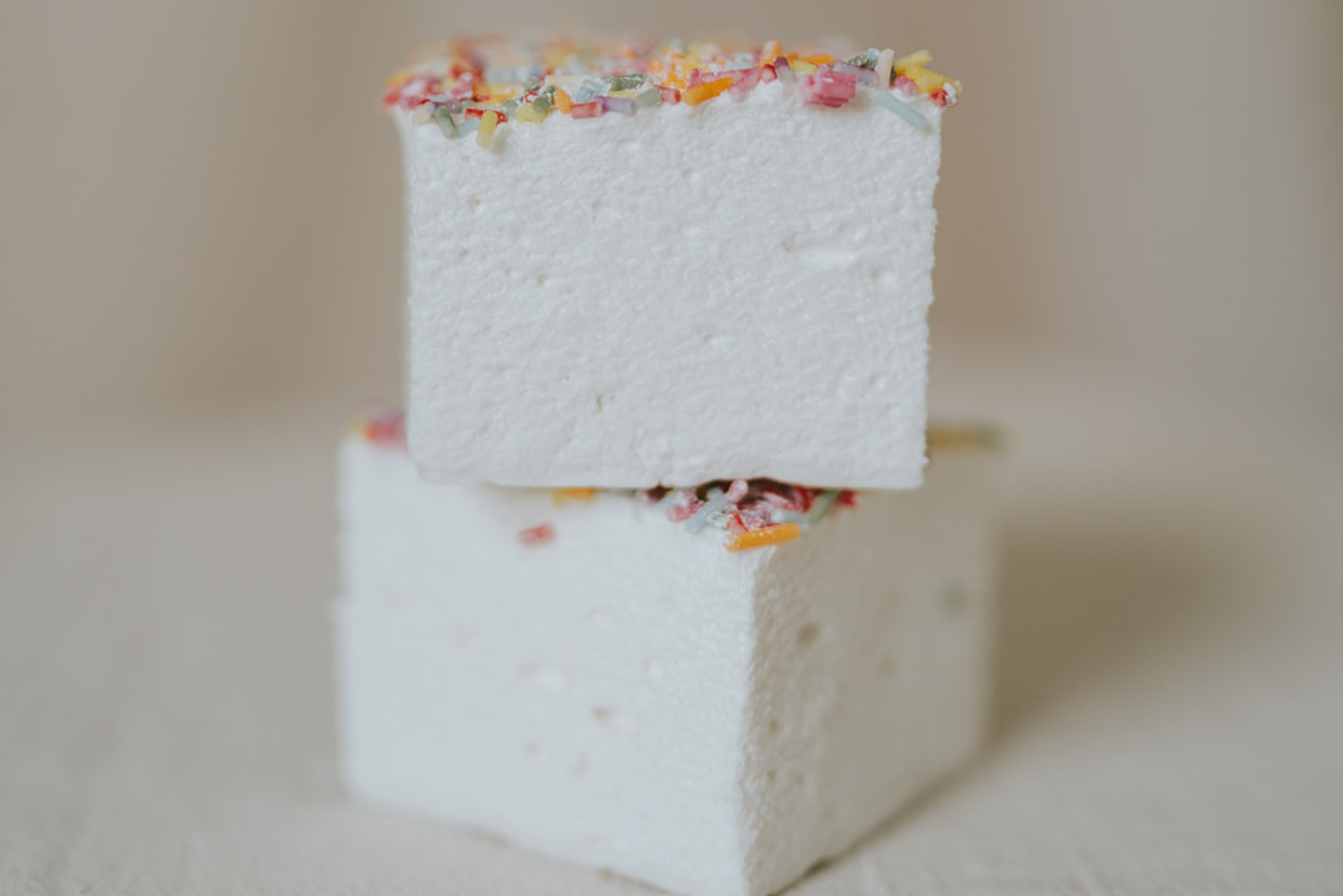 four jumbo vanilla marshmallows with colourful sprinkles