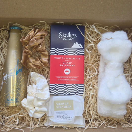Gift box with Skelligs chocolate, a bottle, and other items on straw