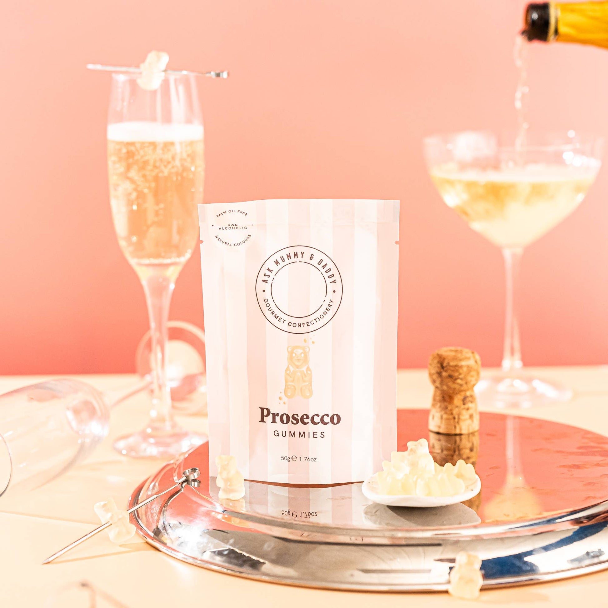 Prosecco gummies packaging with two champagne glasses on a pink background